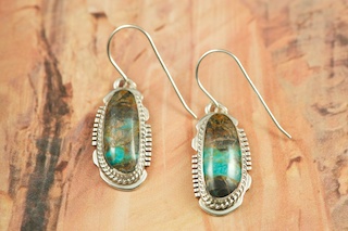 Genuine Sunnyside Turquoise set in Sterling Silver French Wire Earrings. The matrix on this rare stone is outstanding. The Sunnyside mine is located in northern Nevada near the town of Tuscarora in the Tuscarora mountain range. The mine is no longer in operation as it has become part of a gold mining operation and a privately owned ranch. The Sunnyside mine was mined mostly in the 70's. You won't find much of this great turquoise around anymore except for old stashes. Created by Navajo Artist Larson Lee. Signed by the artist.